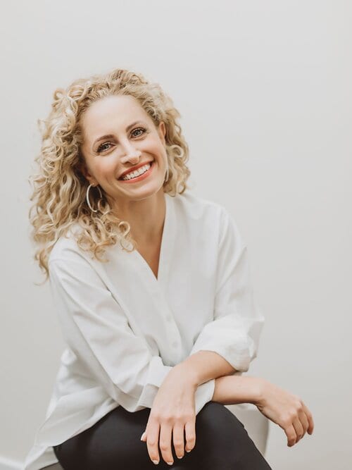 Dr. Inna Vinnikov, DMD, in a white blouse, smiling